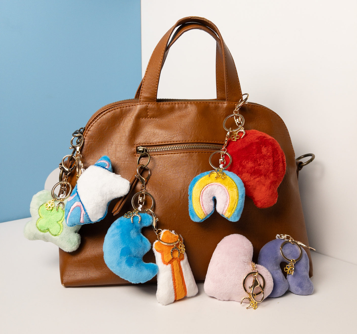 Complete collection of plush fantasy-themed keychains featuring the white unicorn charm attached to a stylish brown leather purse