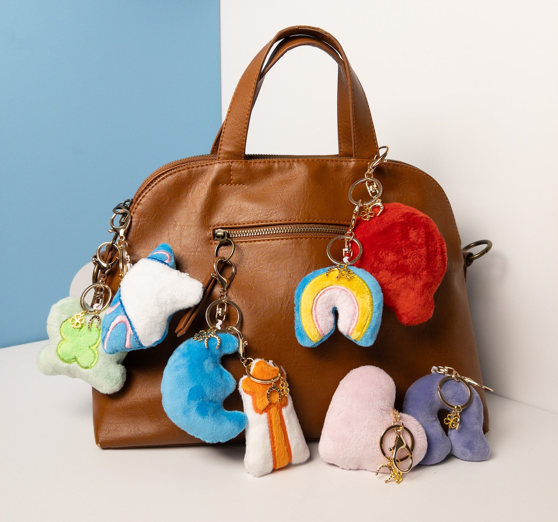 Complete collection of plush fantasy-themed keychains featuring the white unicorn charm attached to a stylish brown leather purse